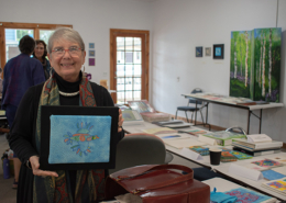 Artist-in-residence Marilyn Olsen showing one of her hand embroidered birds